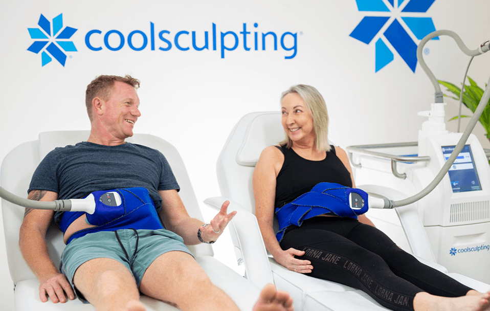 Two people smiling and receiving CoolSculpting treatment